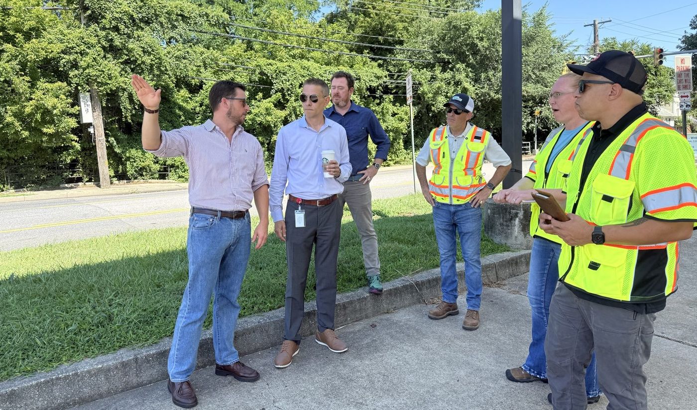 Members of the Propvizer team walk the Spa Road site in Annapolis with public works staff in high-visibility vests, standing along the roadside beside the fenced site.